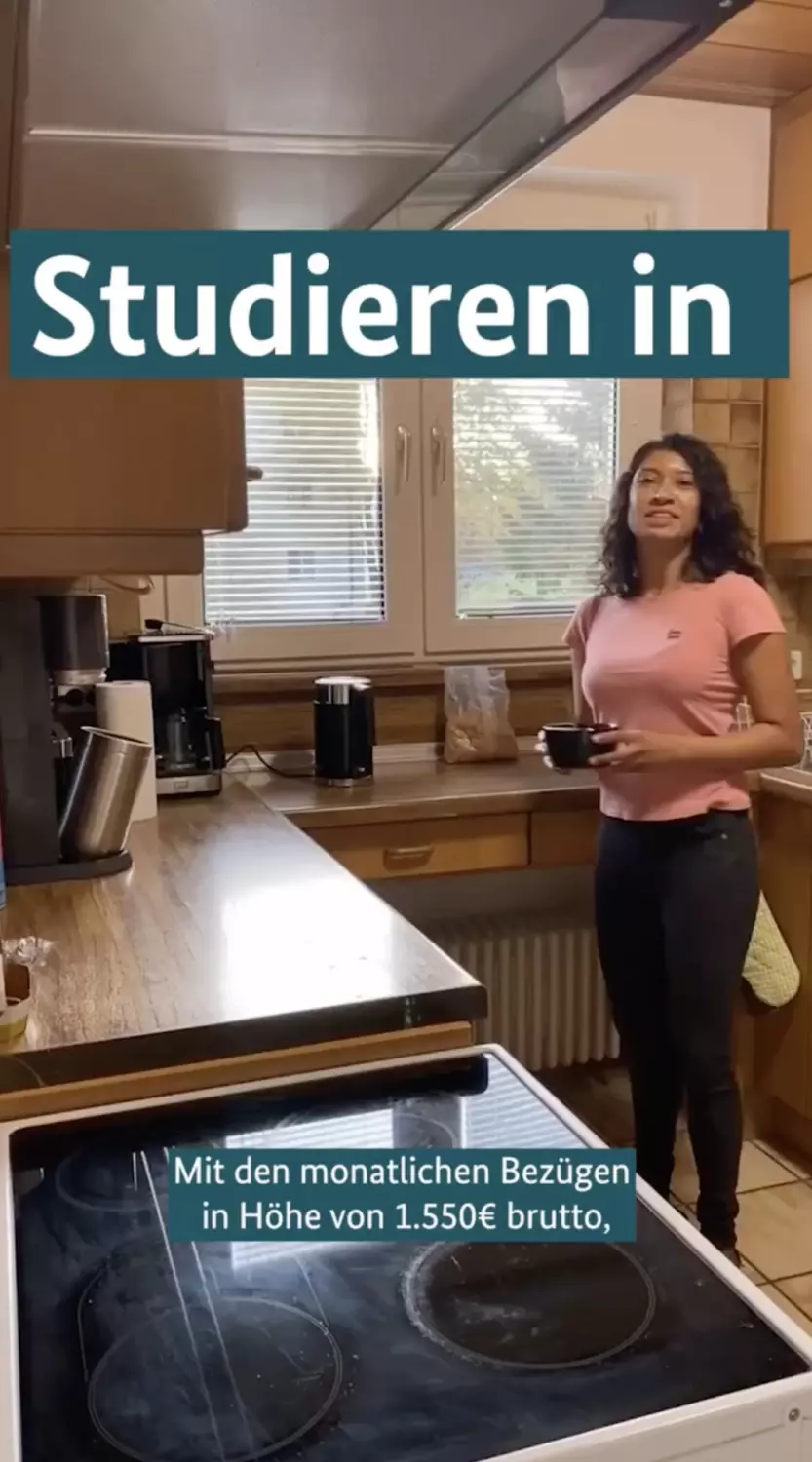 Videoausschnitt: Eine junge Frau steht in einer Küche. Darauf der Text: Studieren in