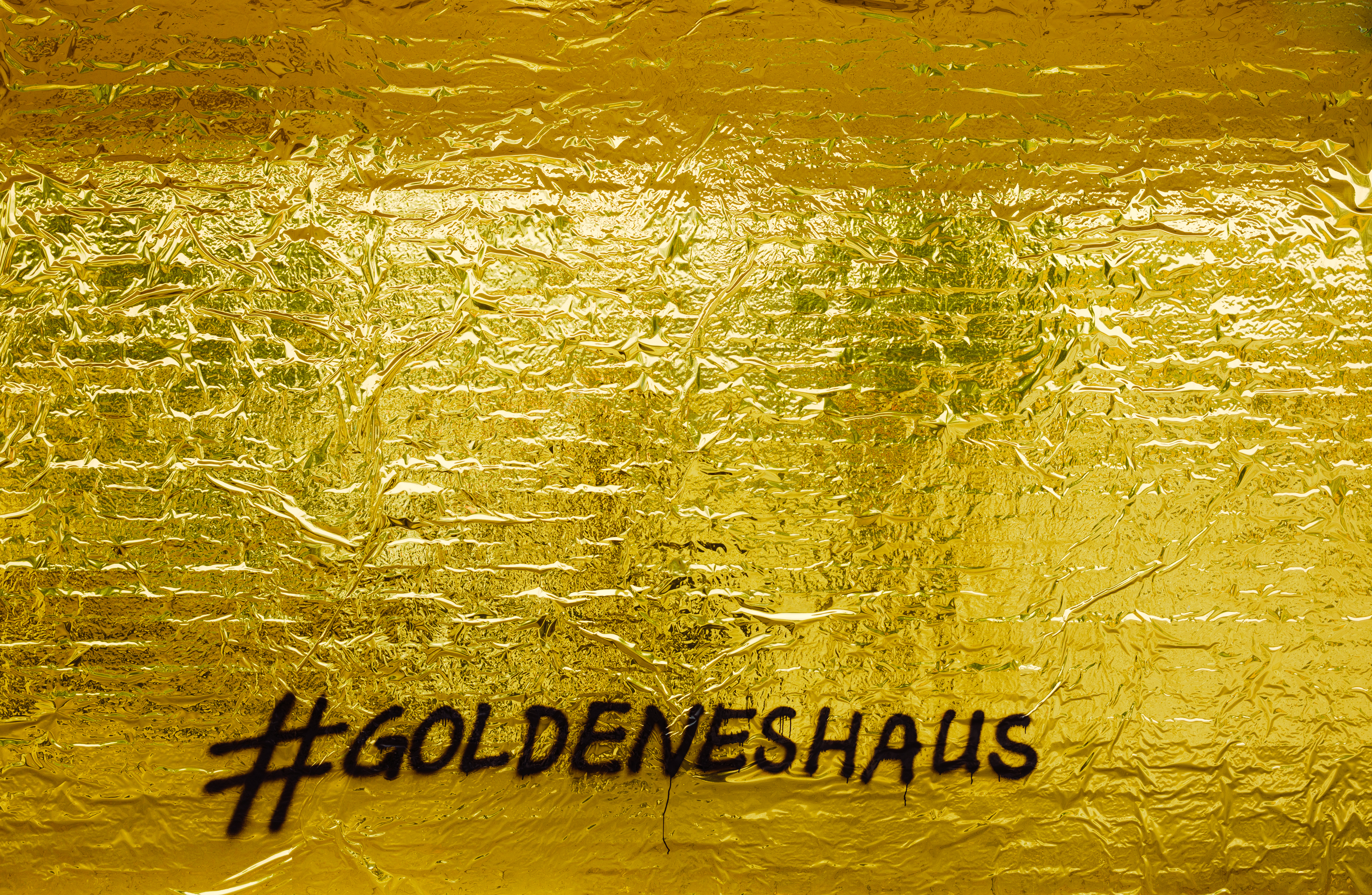 Eine goldene Wand auf der der Schriftzug #goldeneshaus zu lesen ist.